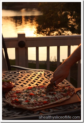 cutting grilled pizza by lake