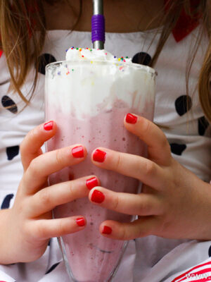 little girl holding milkshake